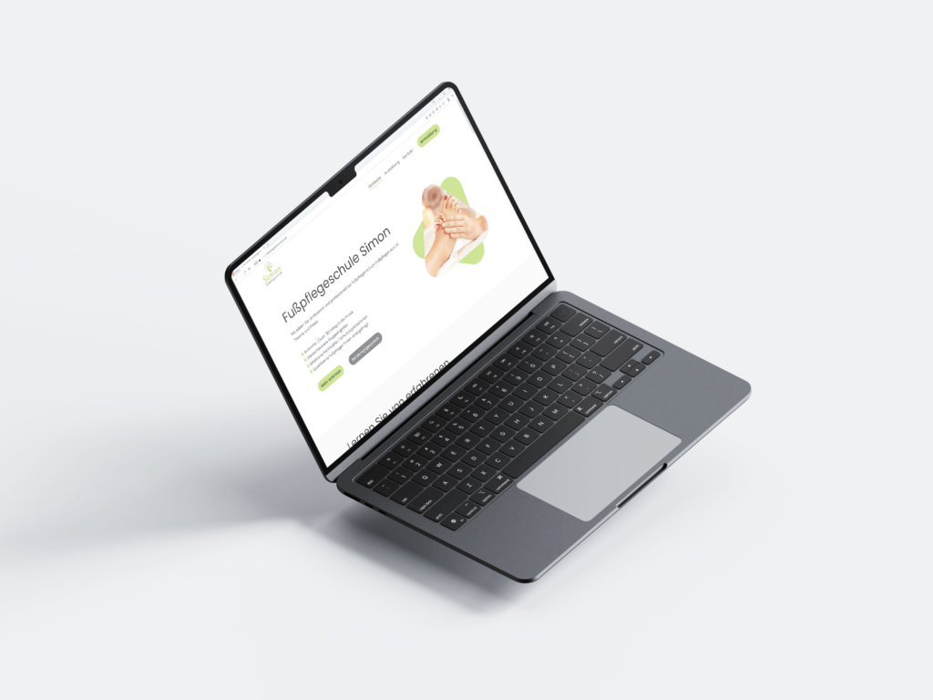Ein aufgeklappter Laptop mit der Website der Fußpflegeschule Simon.